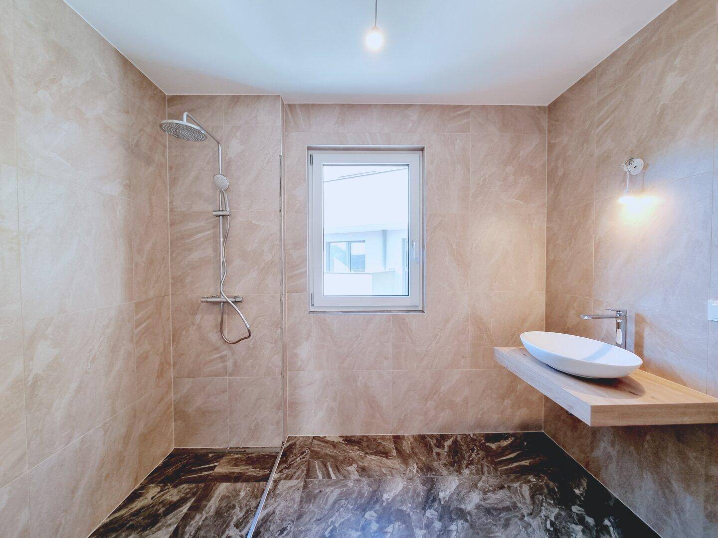 Modernes Badezimmer mit begehbarer Dusche, eleganten Fliesen und schwebendem Waschbecken.