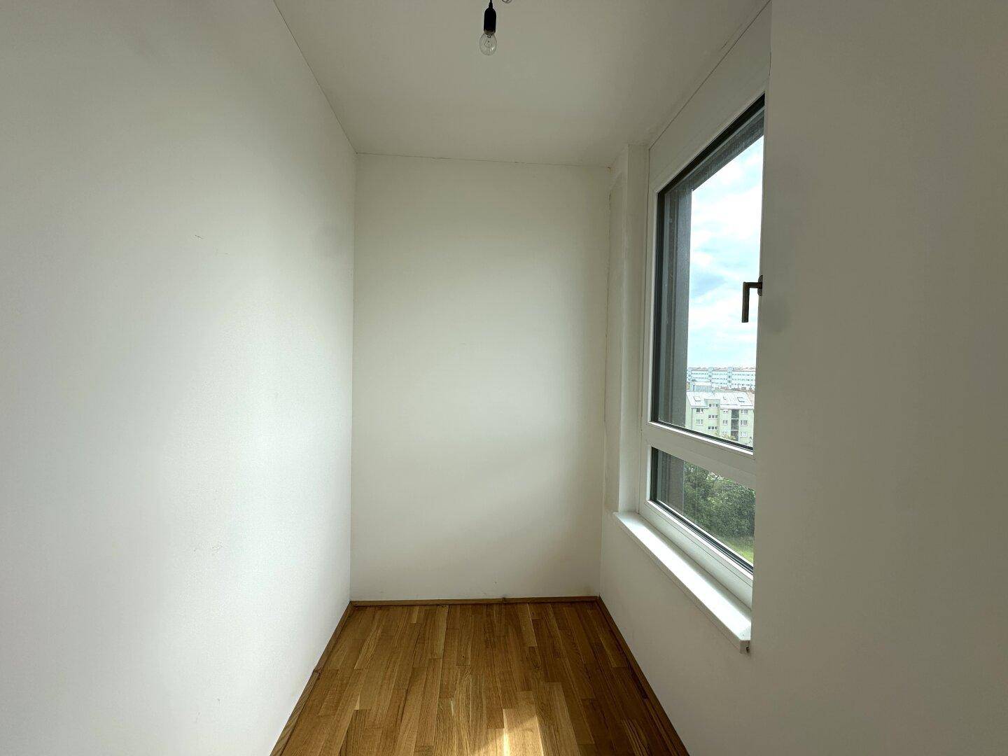 Kleines, helles Zimmer mit Fenster und Parkettboden, ideal als Büro oder Ankleidezimmer nutzbar.