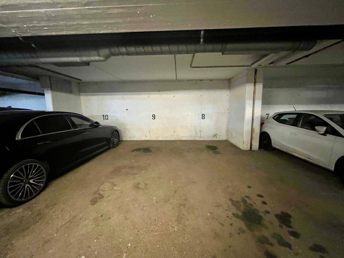 Einzelne Parkplätze in der Tiefgarage, gekennzeichnet mit Nummern an der Wand für einfache Orientierung.
