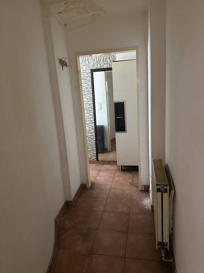 Schmaler Flur mit Fliesenboden und Zugang zu weiteren Räumen der Wohnung.