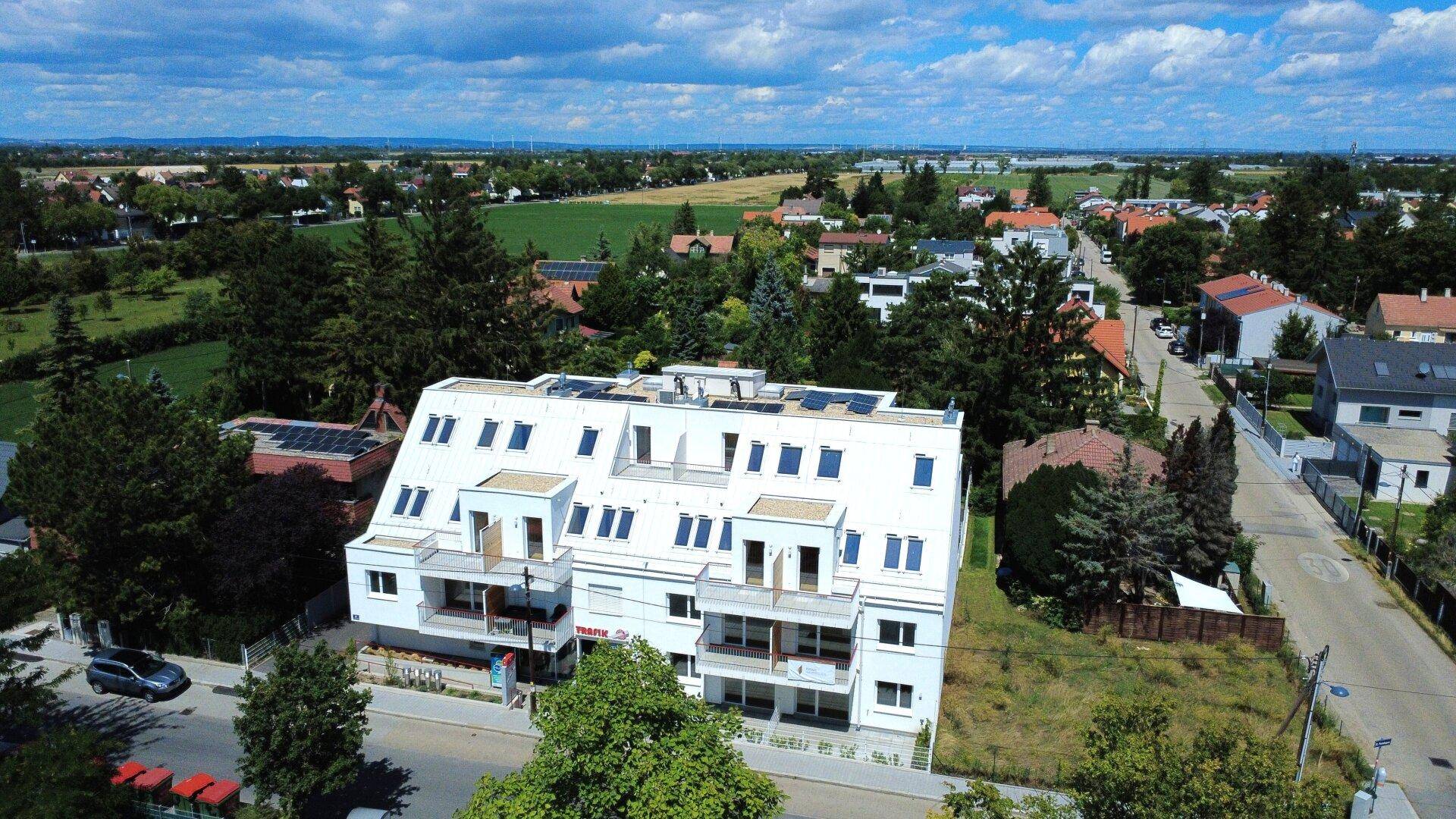 Luftaufnahme des Wohnkomplexes mit Photovoltaikanlage und weitem Blick über die Umgebung.