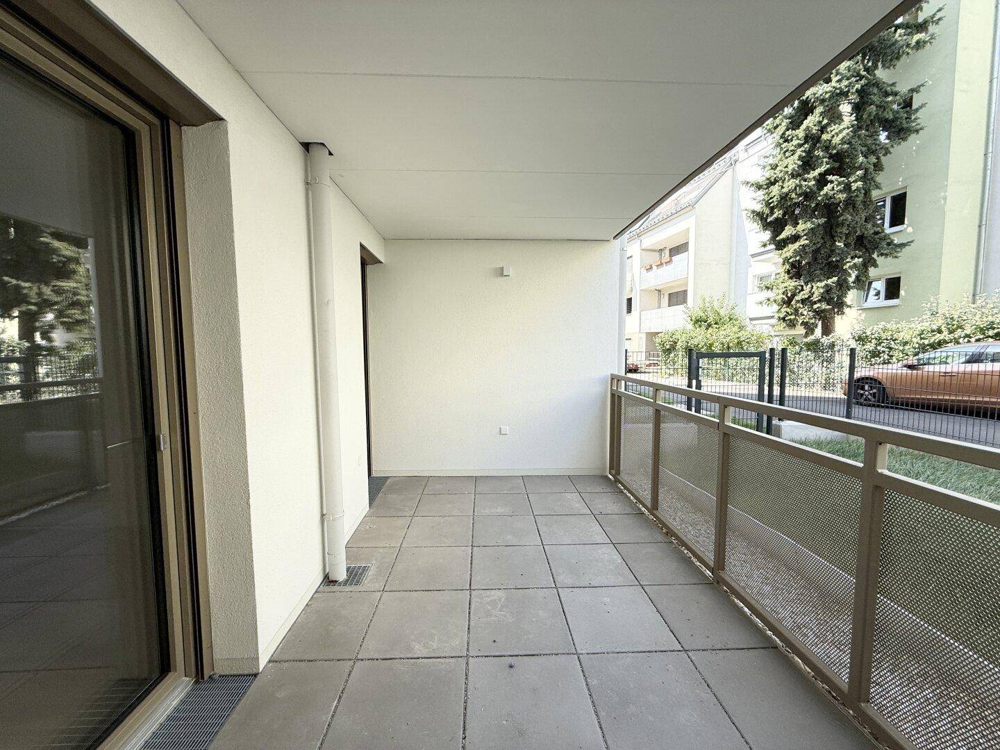 Geräumiger Balkon mit Fliesenboden und Blick auf die umliegende Wohngegend.