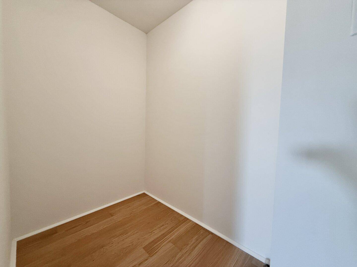 Praktischer Abstellbereich mit Parkettboden, ideal für zusätzlichen Stauraum.