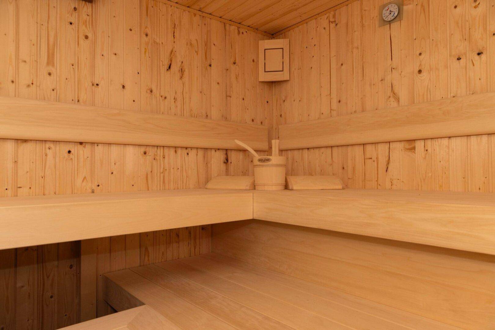 Geräumige Holzsauna mit breiten Bänken und klassischem Design für Entspannung.