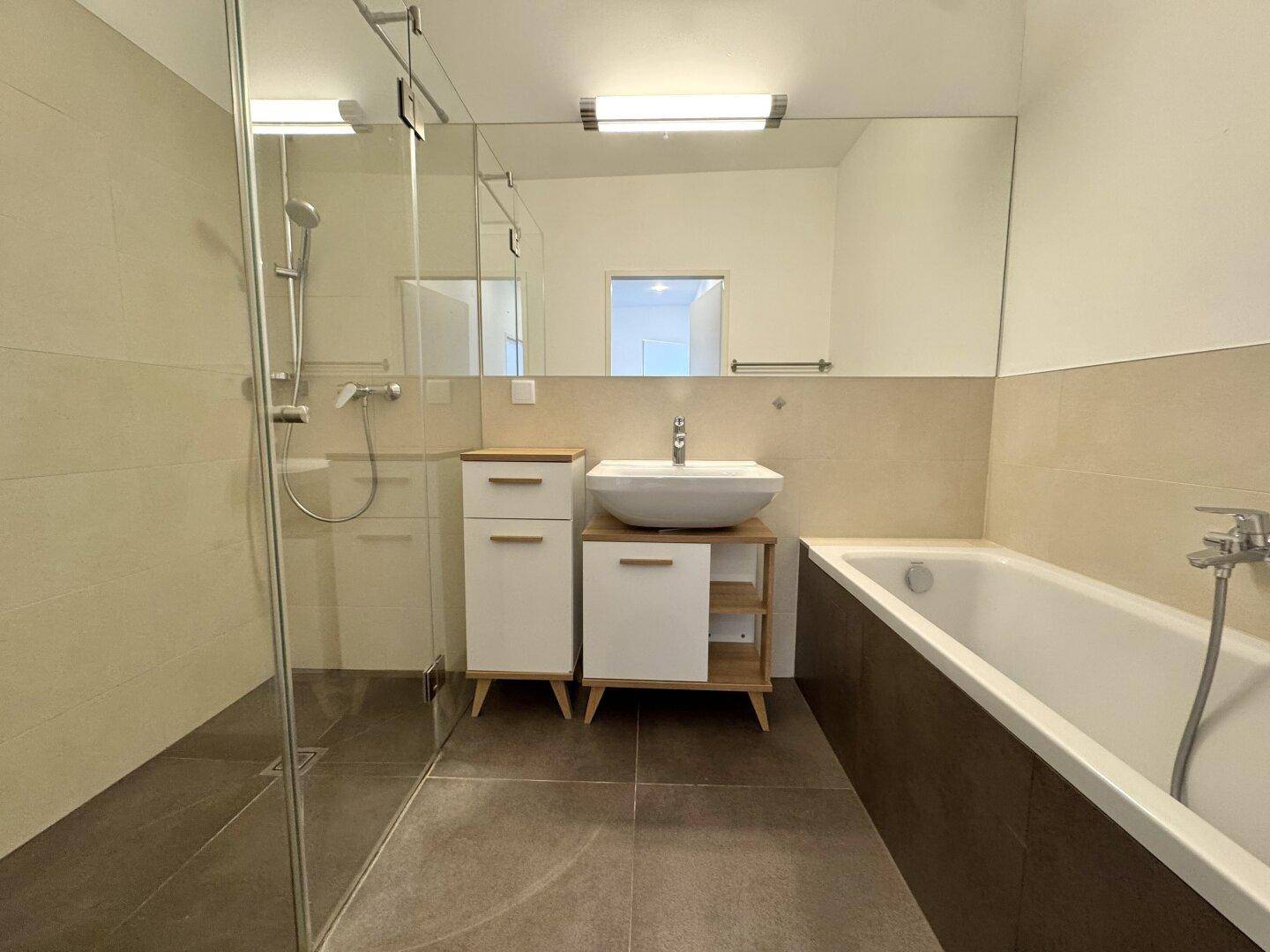 Modernes Badezimmer mit Badewanne, begehbarer Dusche und stilvollem Waschtisch.