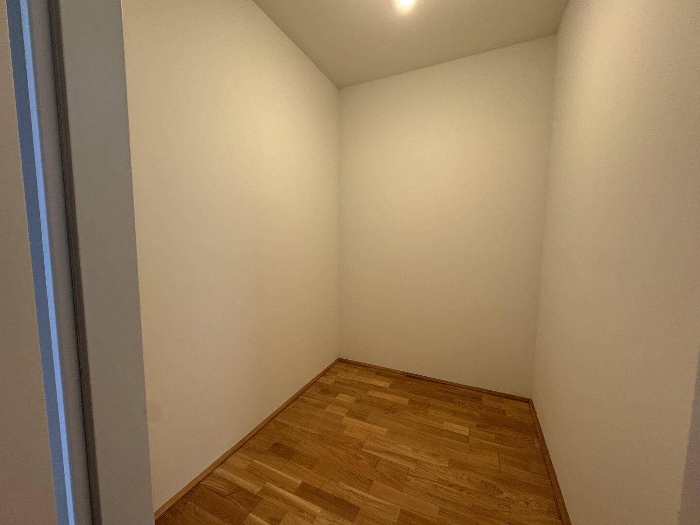 Kleiner, heller Raum mit Parkettboden, ideal als Abstellraum oder begehbarer Kleiderschrank.
