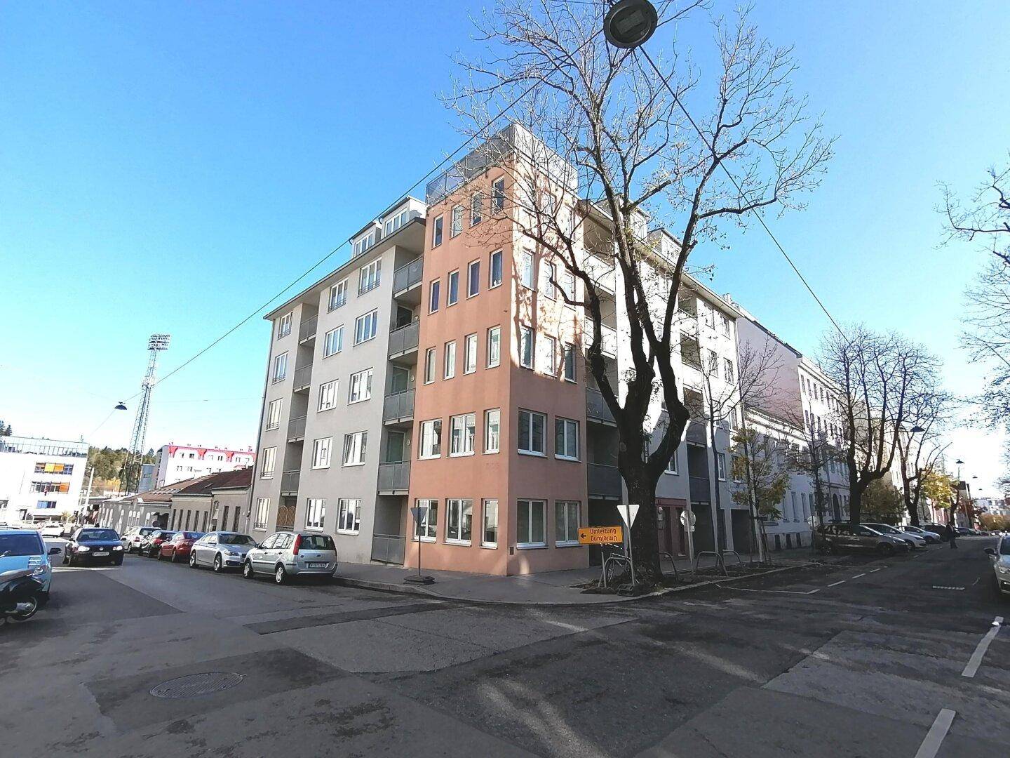 Weitwinkelansicht des modernen Wohnhauses an einer Straßenecke mit umliegender Bebauung.