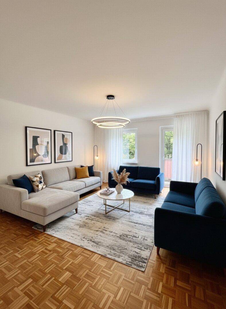Modern eingerichtetes Wohnzimmer mit mehreren Sofas, Parkettboden und Balkonzugang.