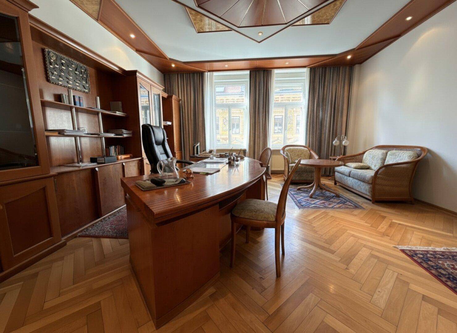 Repräsentatives Büro mit klassischer Einrichtung, Holzelementen und Blick nach draußen.