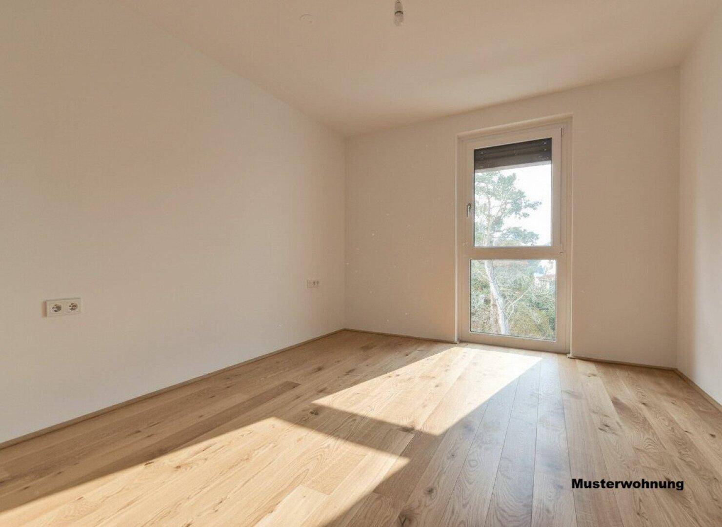 Helles leeres Zimmer mit Holzboden und Fenster, ideal als Schlaf- oder Arbeitszimmer.