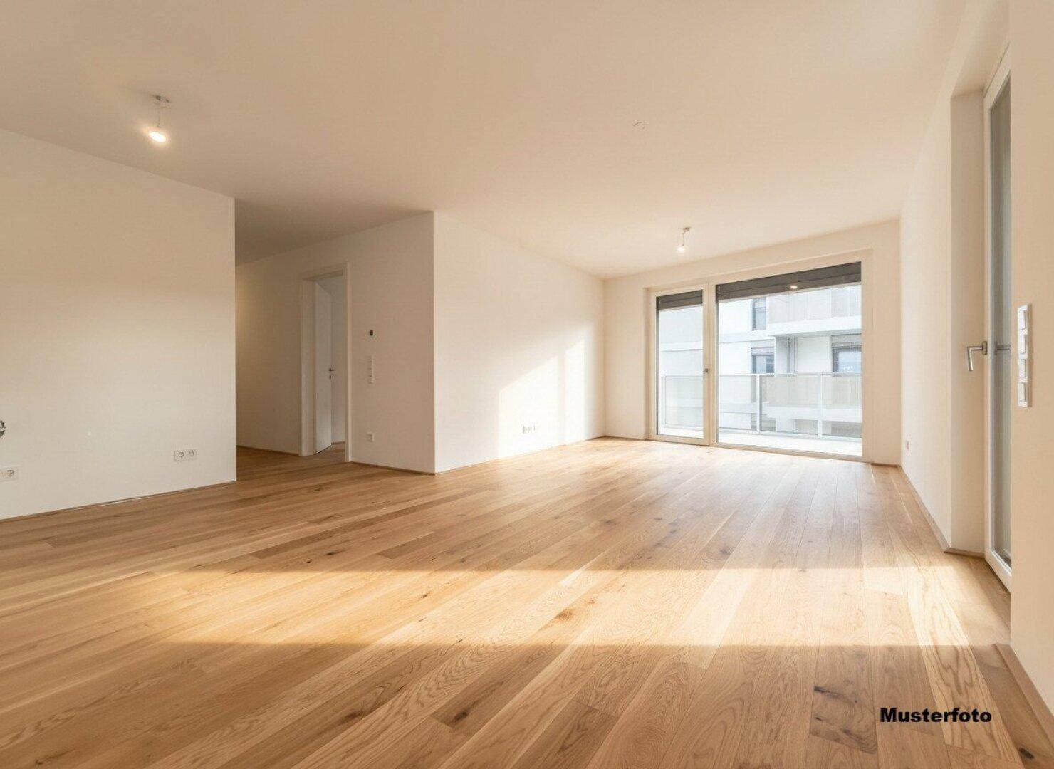 Heller, leerer Wohnbereich mit großen Fenstern und Holzboden, bereit zur individuellen Gestaltung.