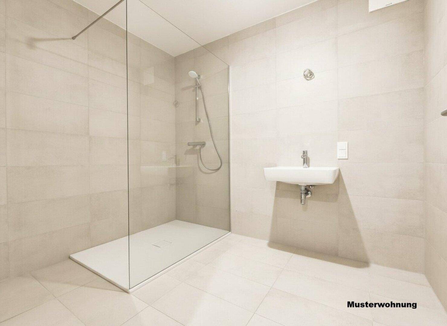 Modernes Badezimmer mit ebenerdiger Dusche, hellen Fliesen und minimalistischem Design.