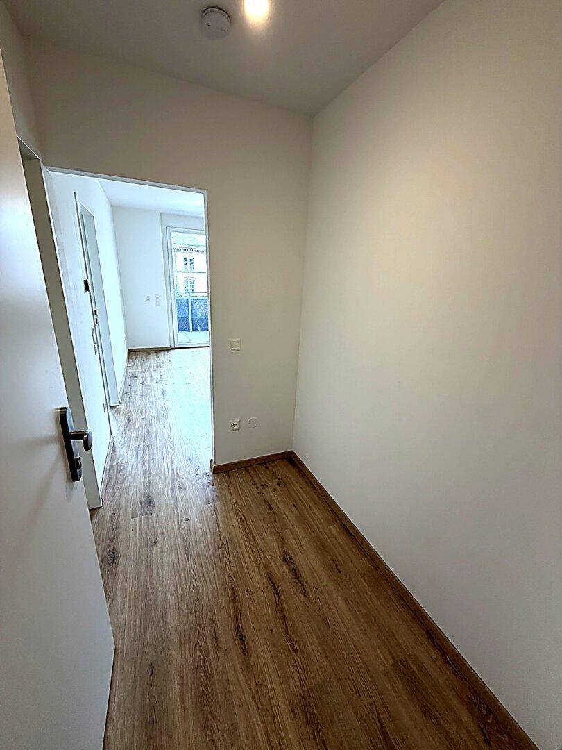 Heller Flur mit Laminatboden, der zu weiteren Räumen der Wohnung führt.