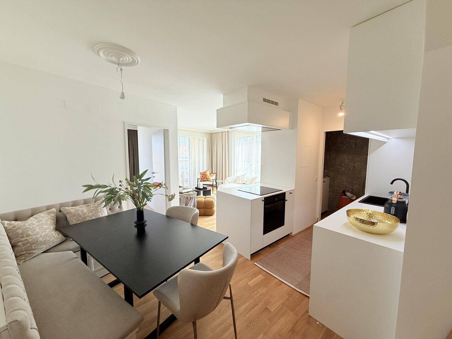 Moderne Küche mit Essbereich, Kochinsel und Blick in den Wohnbereich.