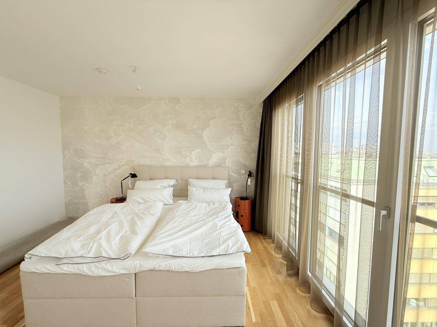 Geräumiges Schlafzimmer mit Doppelbett, Parkettboden und weitem Ausblick.