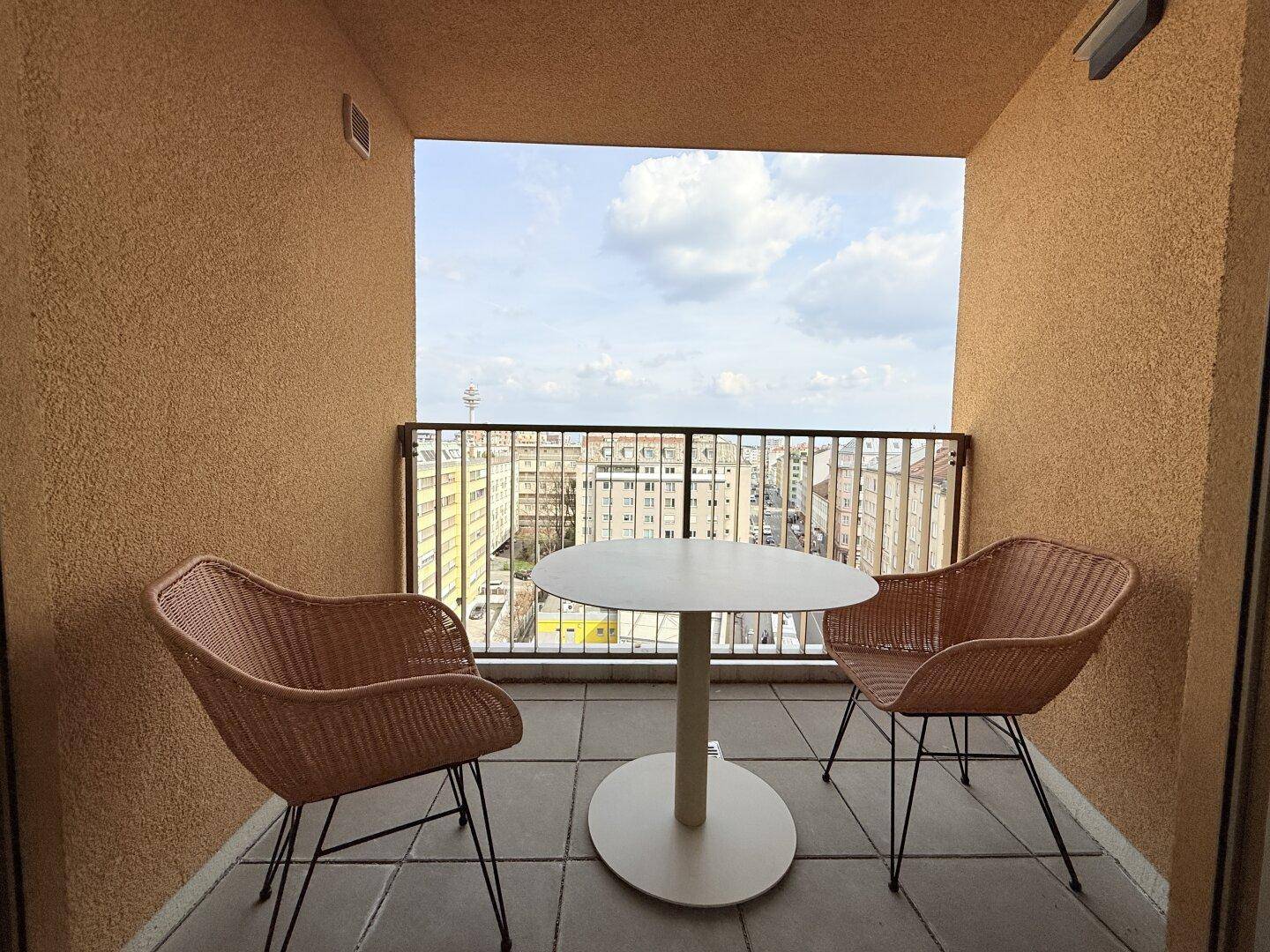 Gemütlicher Balkon mit Sitzgelegenheiten und weitem Blick über die Stadt.