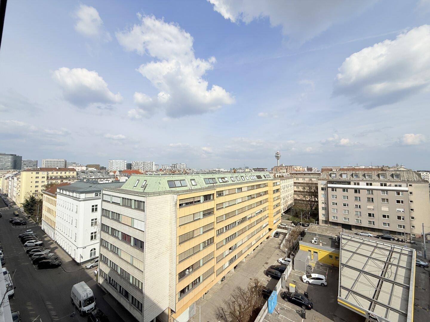 Weitläufiger Blick über die Stadt mit verschiedenen Gebäuden und dem Himmel.