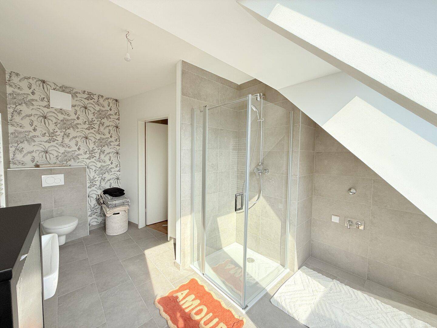 Modernes Badezimmer mit Dusche, Wand-WC und Dachfenstern für viel Licht.