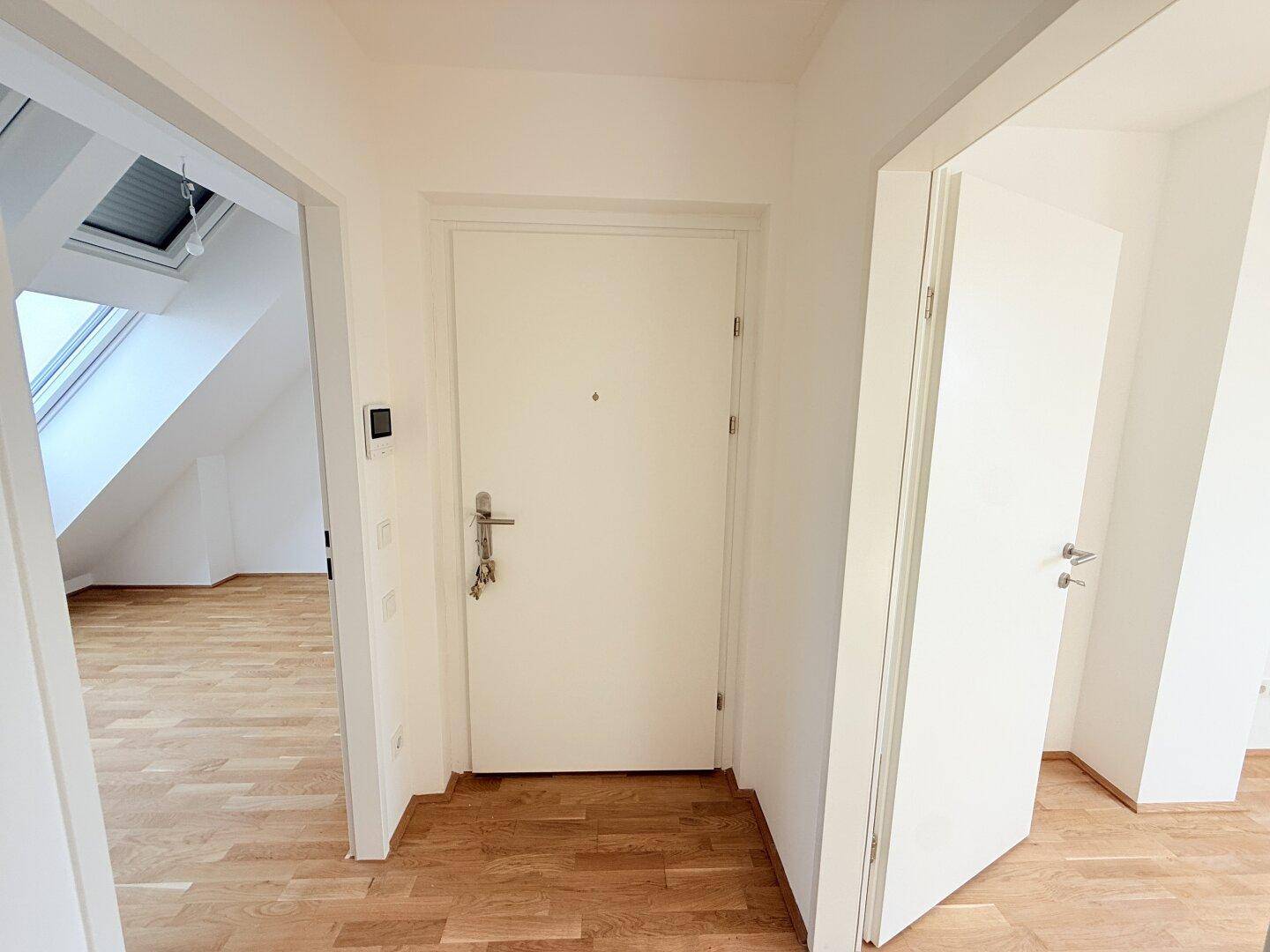Eingangsbereich mit Holzboden und Zugang zu den hellen Dachgeschossräumen, einladend gestaltet.
