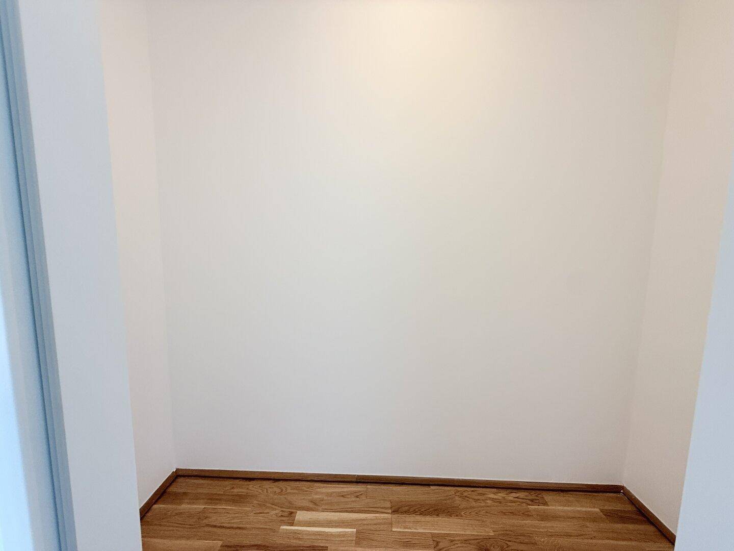 Kleiner, leerer Abstellraum mit Parkettboden, ideal für zusätzlichen Stauraum.