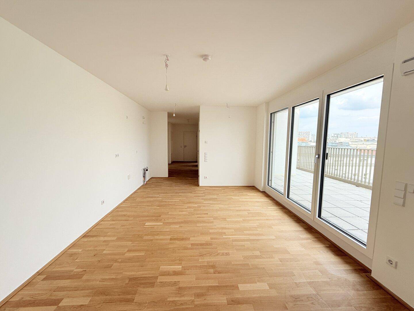 Geräumiges, helles Zimmer mit Holzboden und Blick auf die Stadt von der Terrasse.