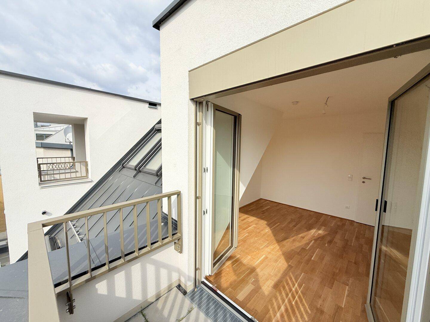 Balkon mit Zugang zu einem hellen Innenraum, bietet eine schöne Verbindung nach draußen.