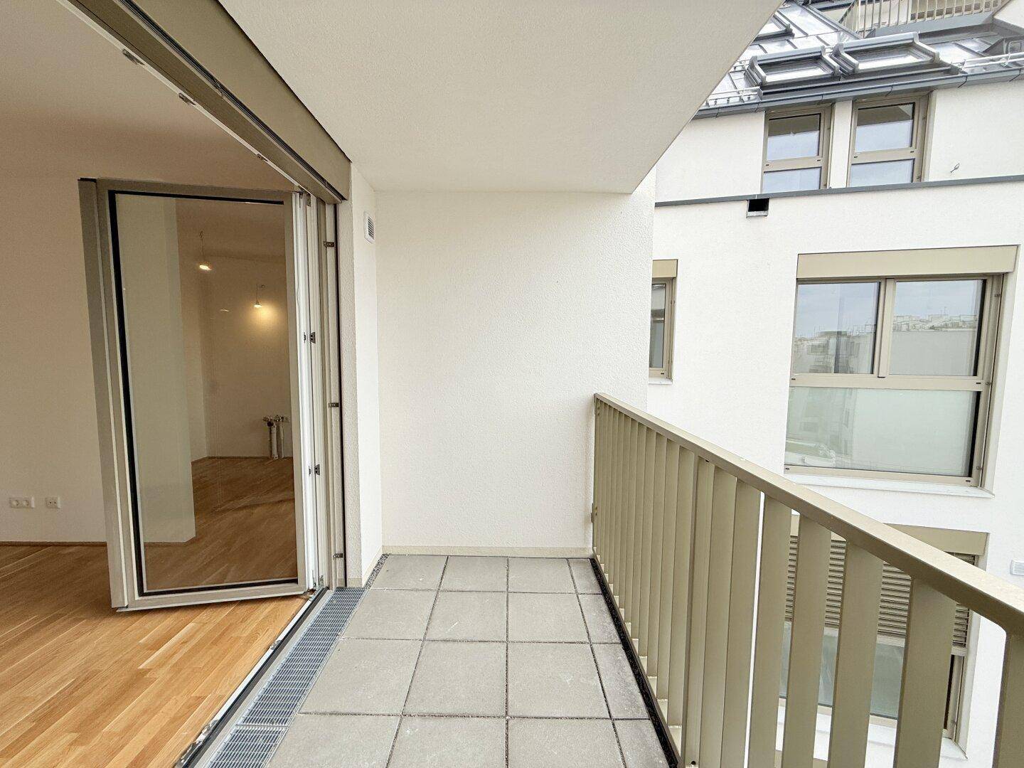 Geräumiger Balkon mit Fliesenboden und Blick auf die Umgebung, ideal zum Entspannen.