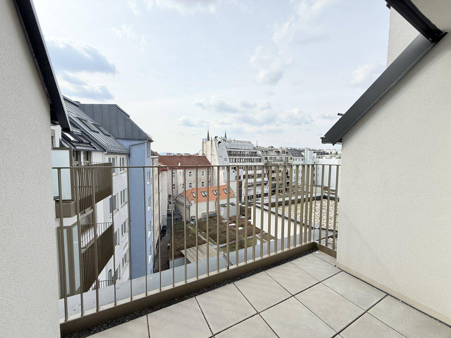 Heller Balkon mit Fliesen und modernem Geländer, ideal für entspannte Stunden im Freien.