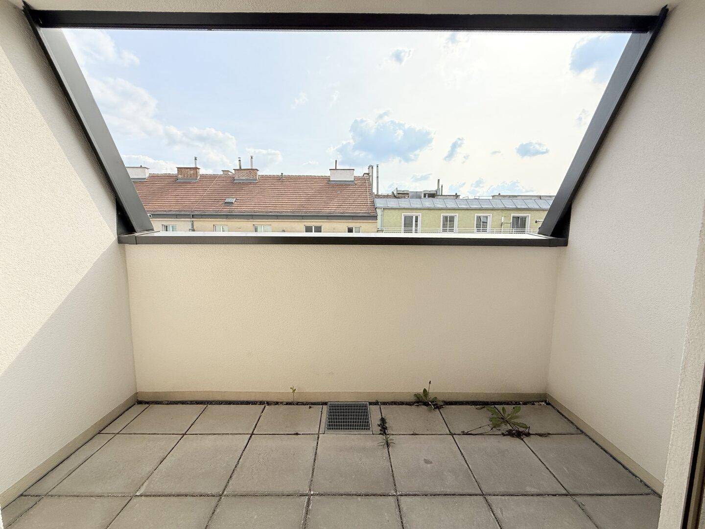 Heller Balkon mit Fliesenboden und offener Aussicht, bietet Platz für eine kleine Sitzgelegenheit.