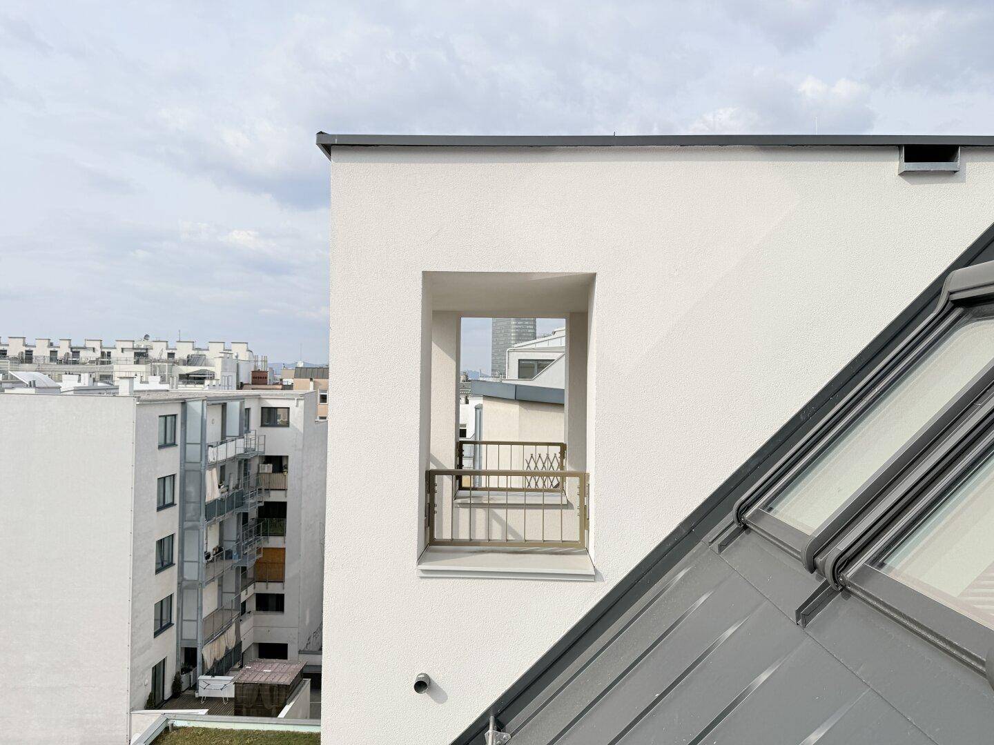 Außenansicht des Gebäudes mit Dachfenstern und einem kleinen französischen Balkon.
