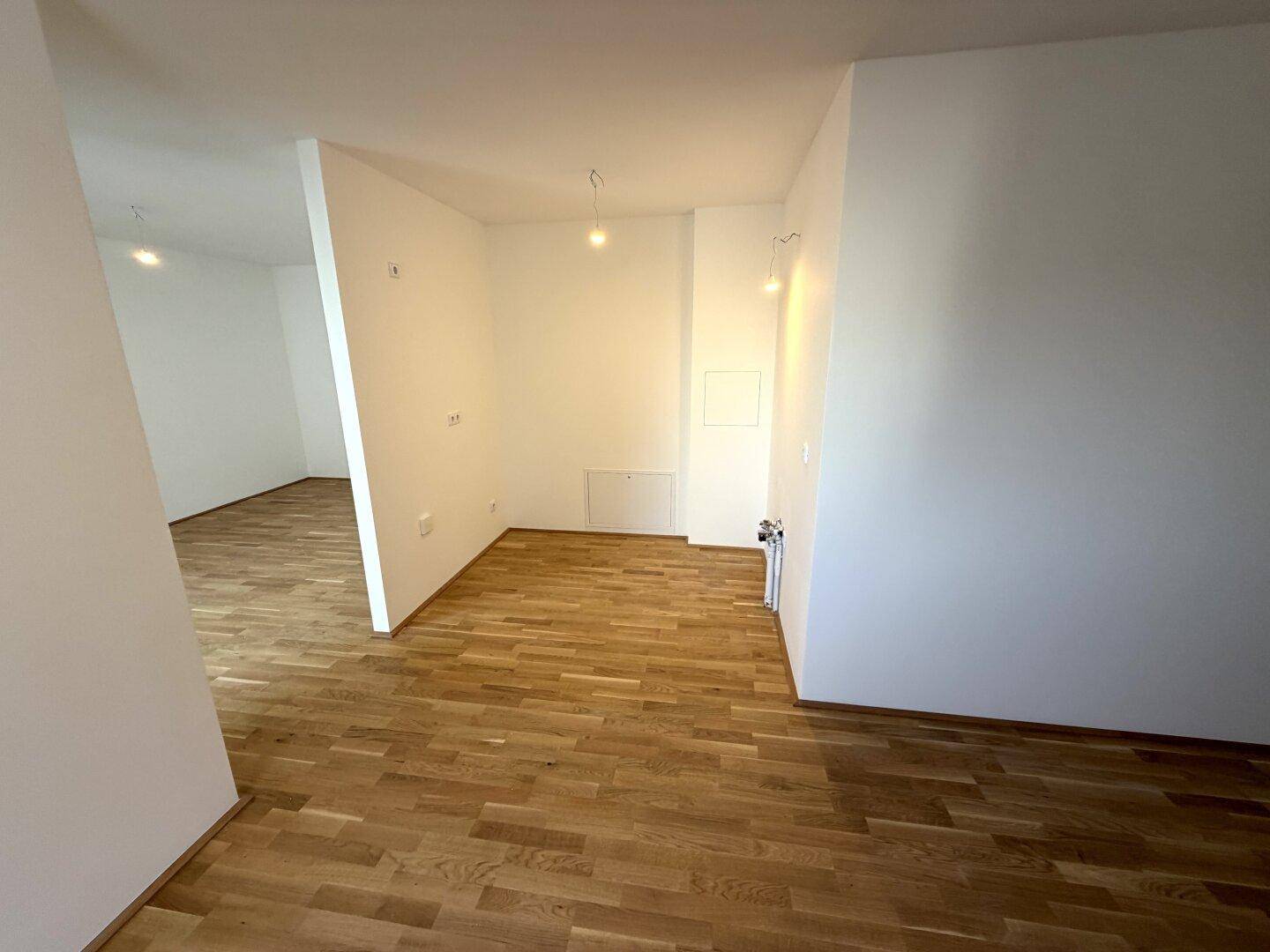 Heller Flurbereich mit Parkettboden, der zu weiteren Räumen der Wohnung führt.