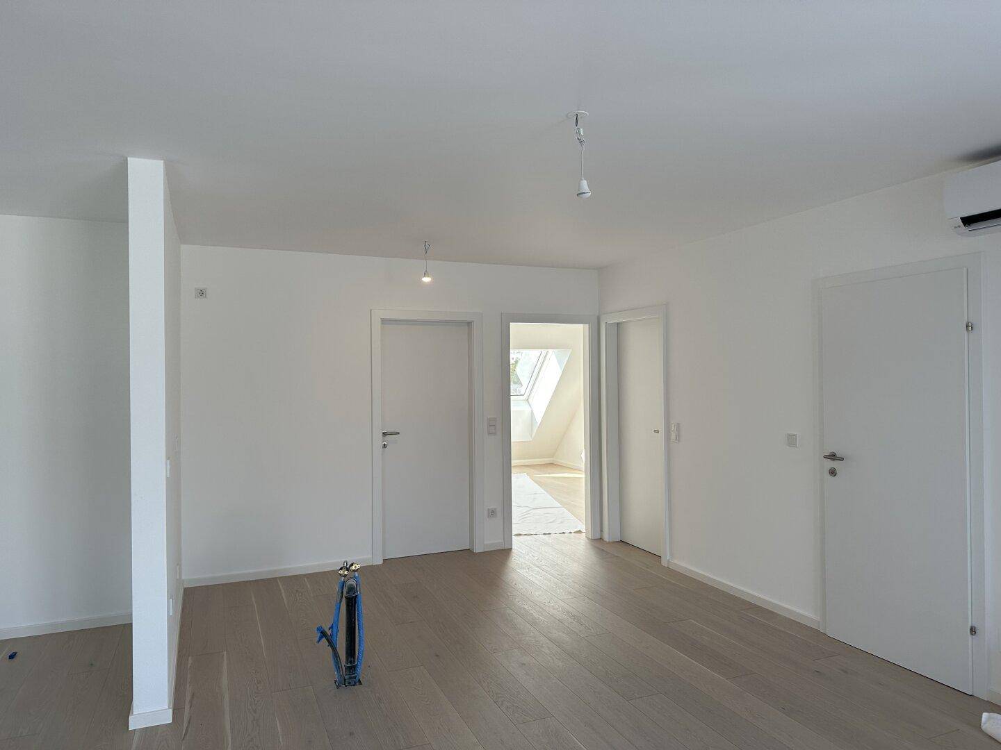 Heller Flur mit Holzboden und mehreren Türen, die zu verschiedenen Räumen führen.