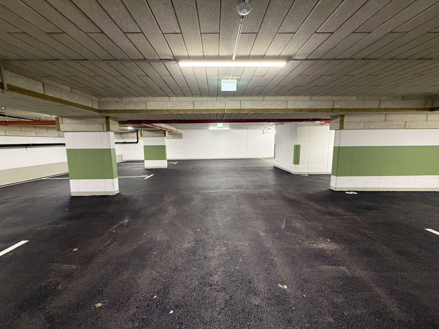 Geräumige Tiefgarage mit markierten Stellplätzen und guter Beleuchtung.