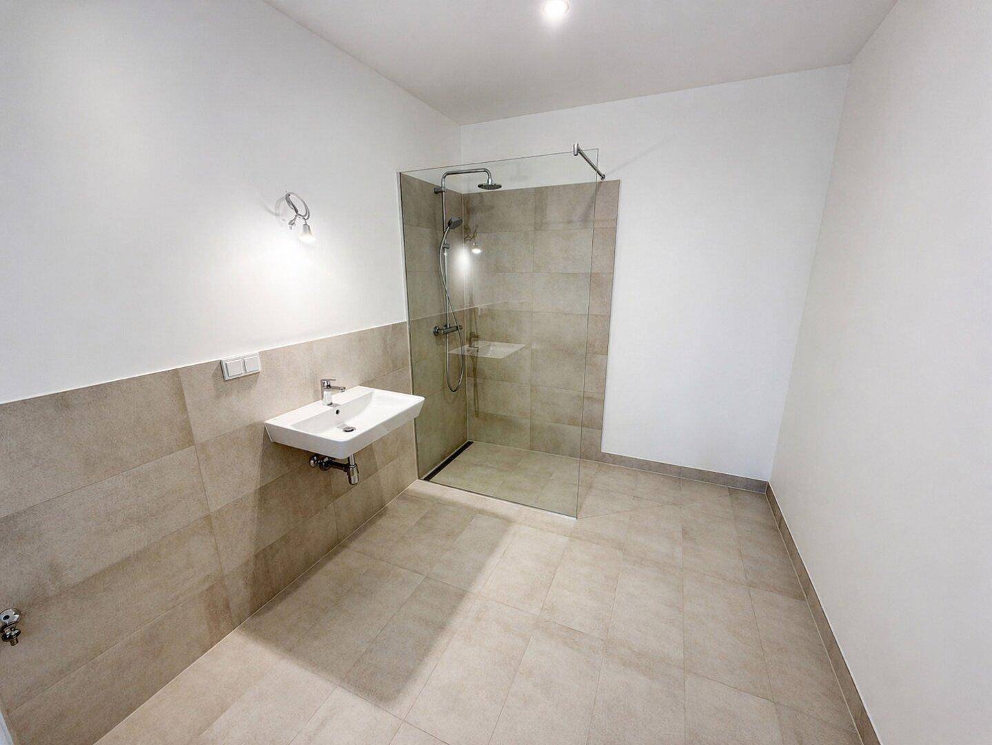 Modernes Badezimmer mit begehbarer Dusche, Wandfliesen und einem einzelnen Waschbecken.