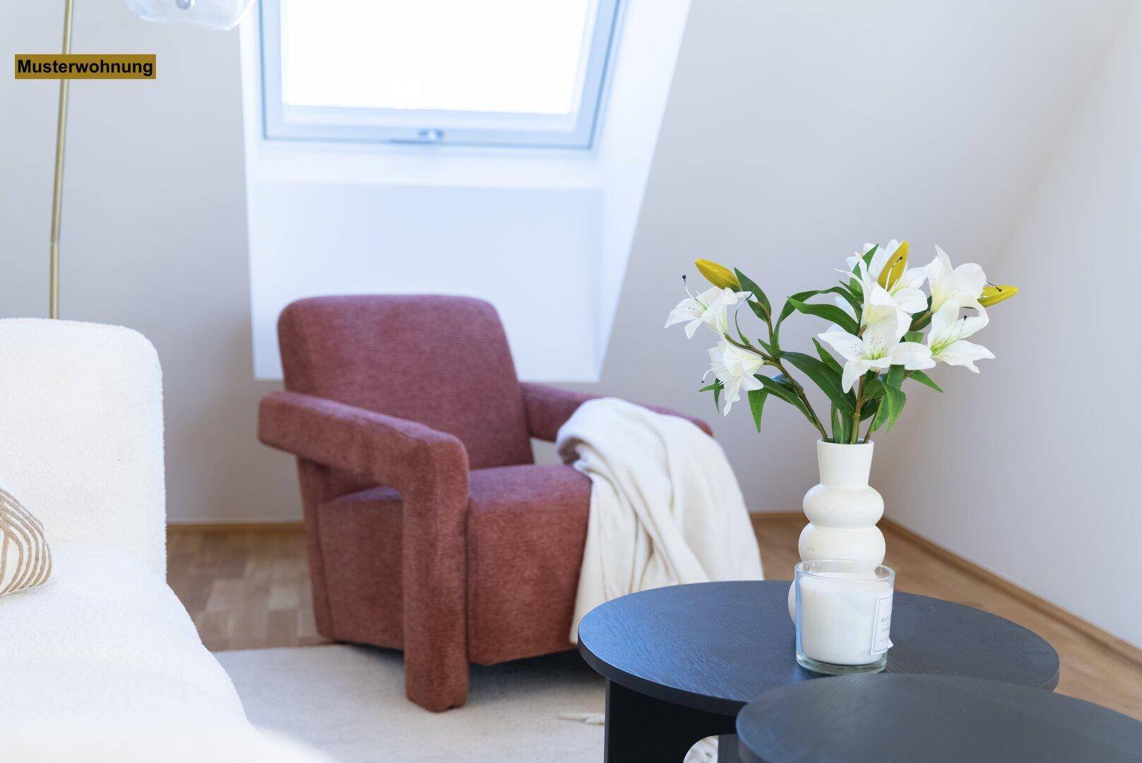 Nahaufnahme des Sessels und Couchtisches mit Blumen im Wohnbereich.