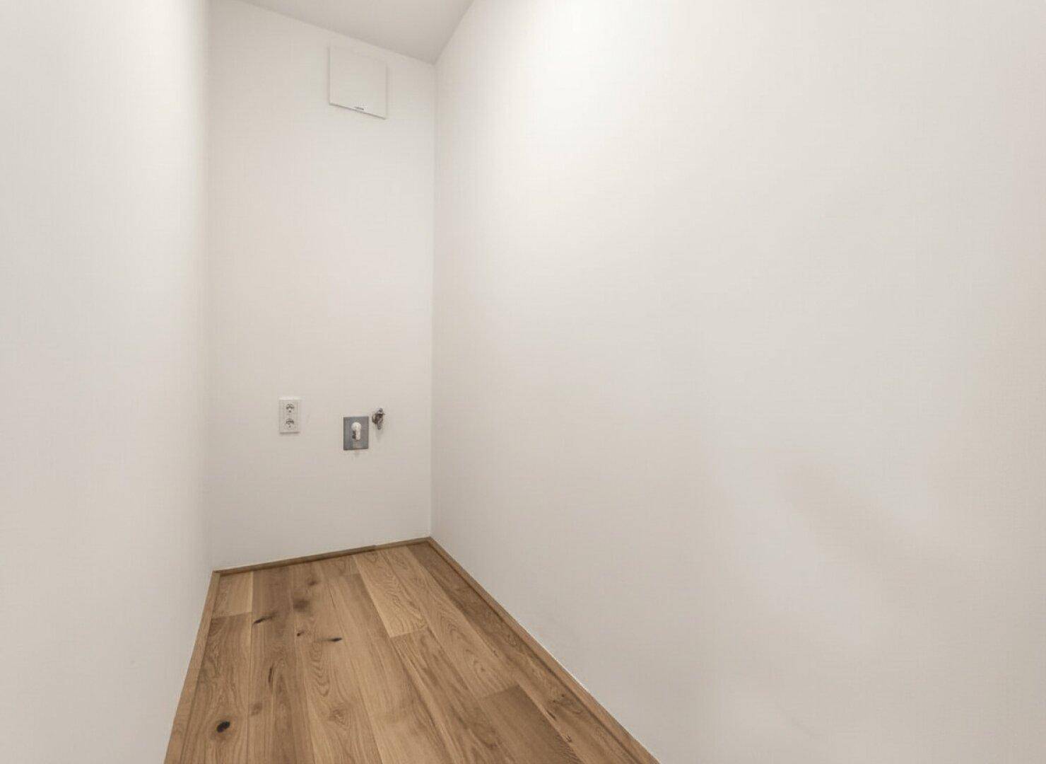 Praktischer Hauswirtschaftsraum mit Anschlüssen für Waschmaschine und Trockner.