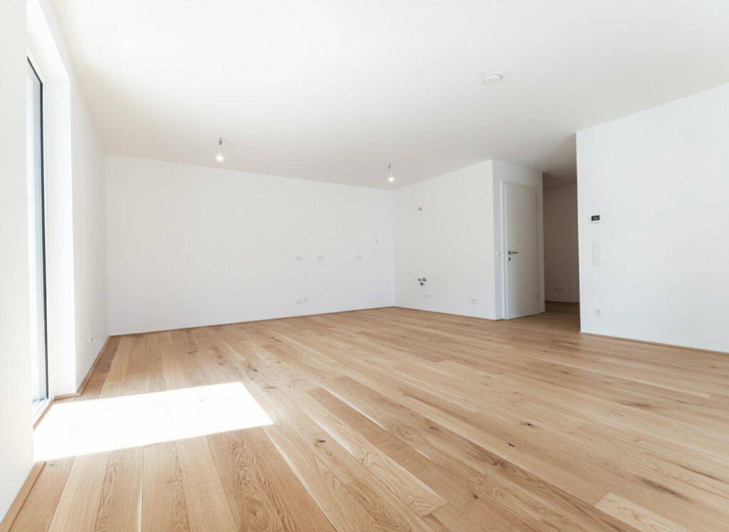 Heller, leerer Raum mit Eichenparkett und viel Tageslicht, perfekt für ein modernes Zuhause.