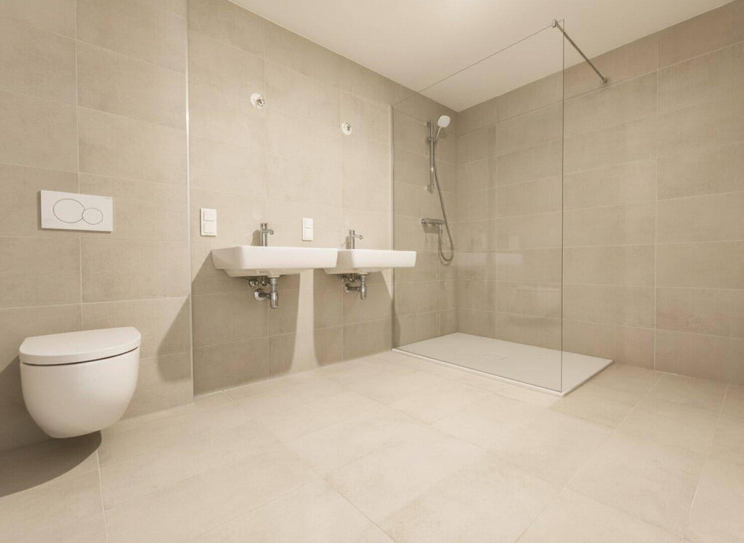Modernes Badezimmer mit beigefarbenen Fliesen, Doppelwaschbecken und einer ebenerdigen Dusche.