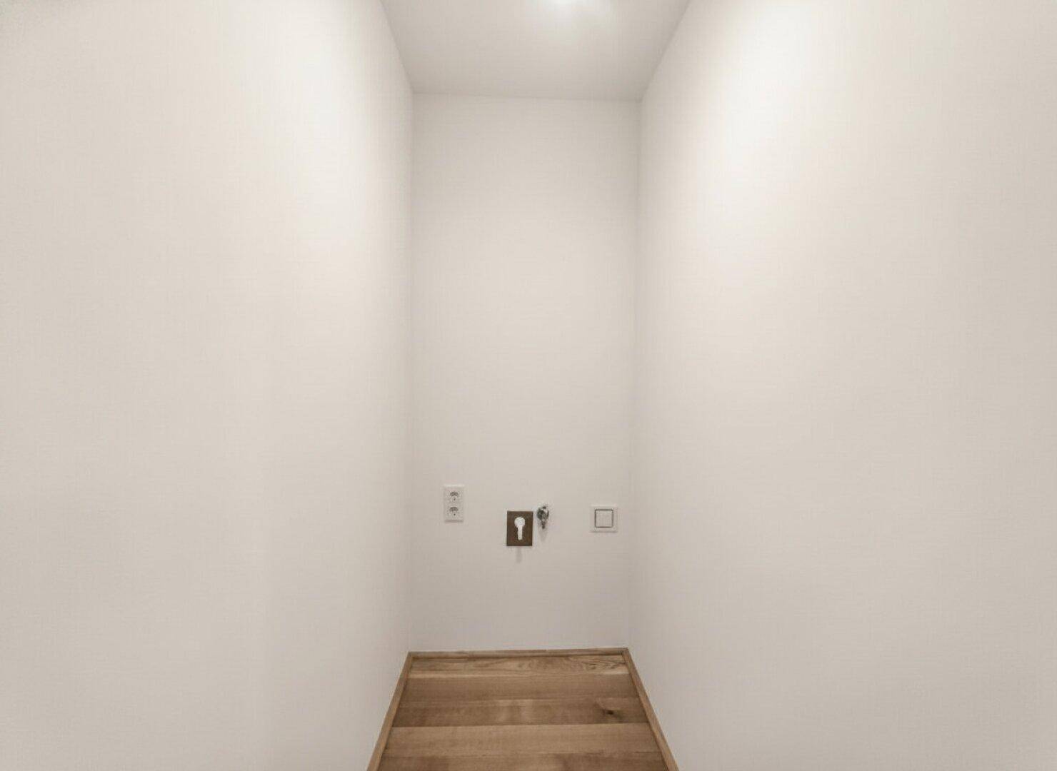 Kleiner Hauswirtschaftsraum mit Anschlüssen für Waschmaschine und Trockner.