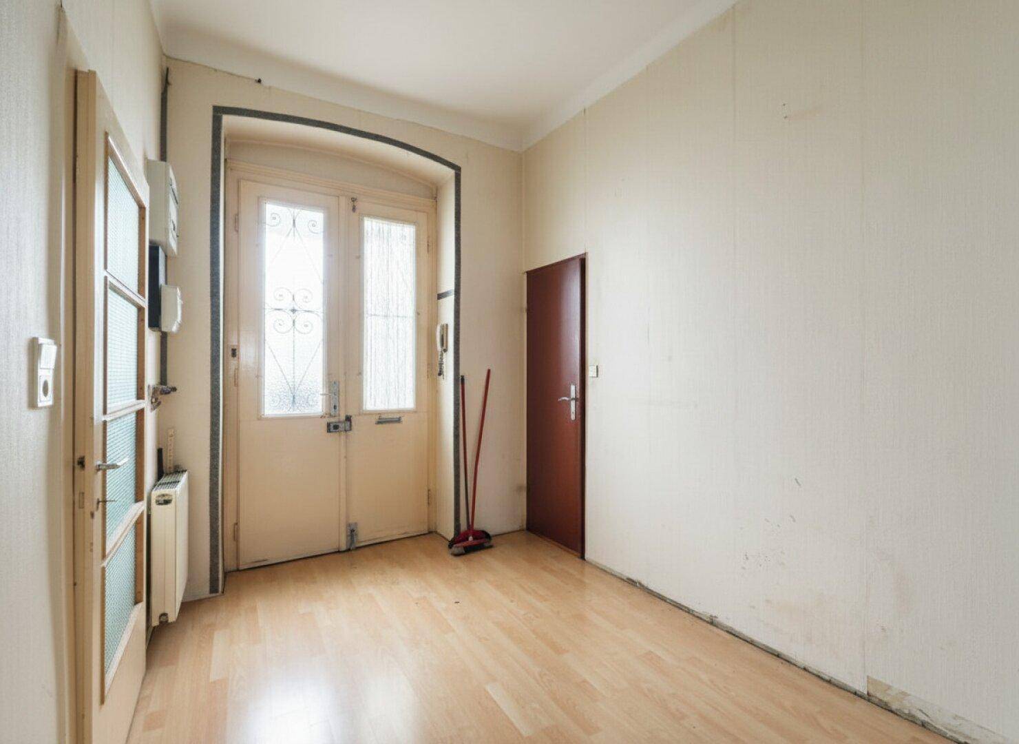 Eingangsbereich mit Laminatboden, einer Doppeltür und weiteren Türen.
