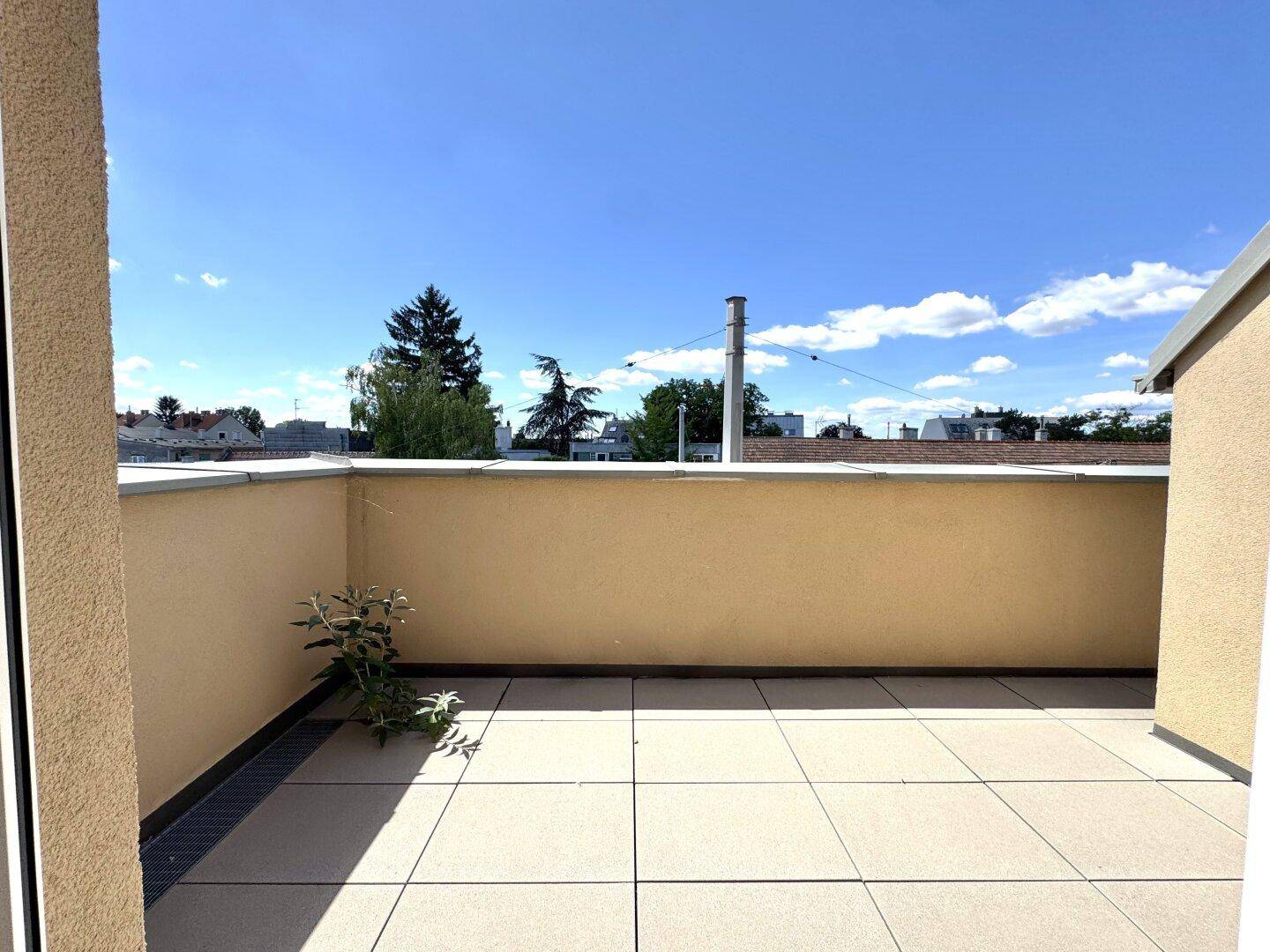 Geräumige Dachterrasse mit Fliesenboden und weitem Blick über die Dächer der Stadt.