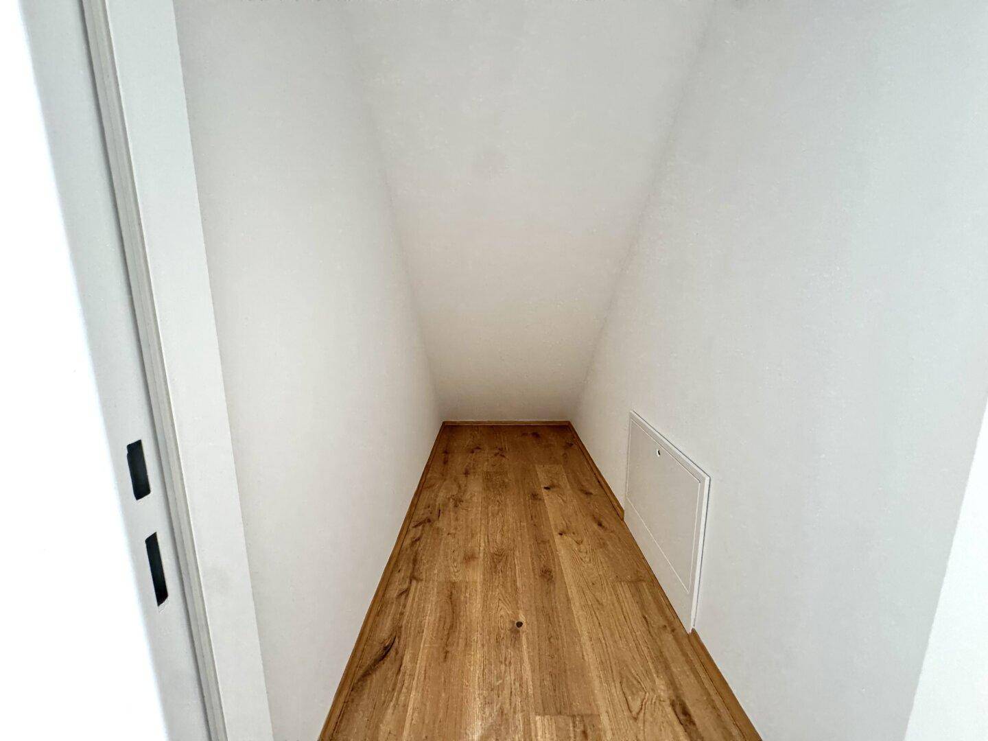 Praktischer Abstellraum mit Holzboden und Dachschräge, ideal für zusätzlichen Stauraum.