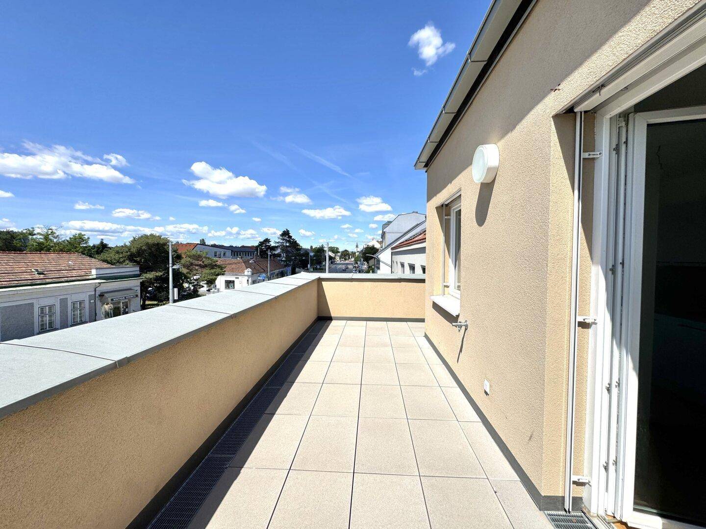 Geräumige Sonnenterrasse mit Fliesenboden und weitem Blick über die Umgebung.