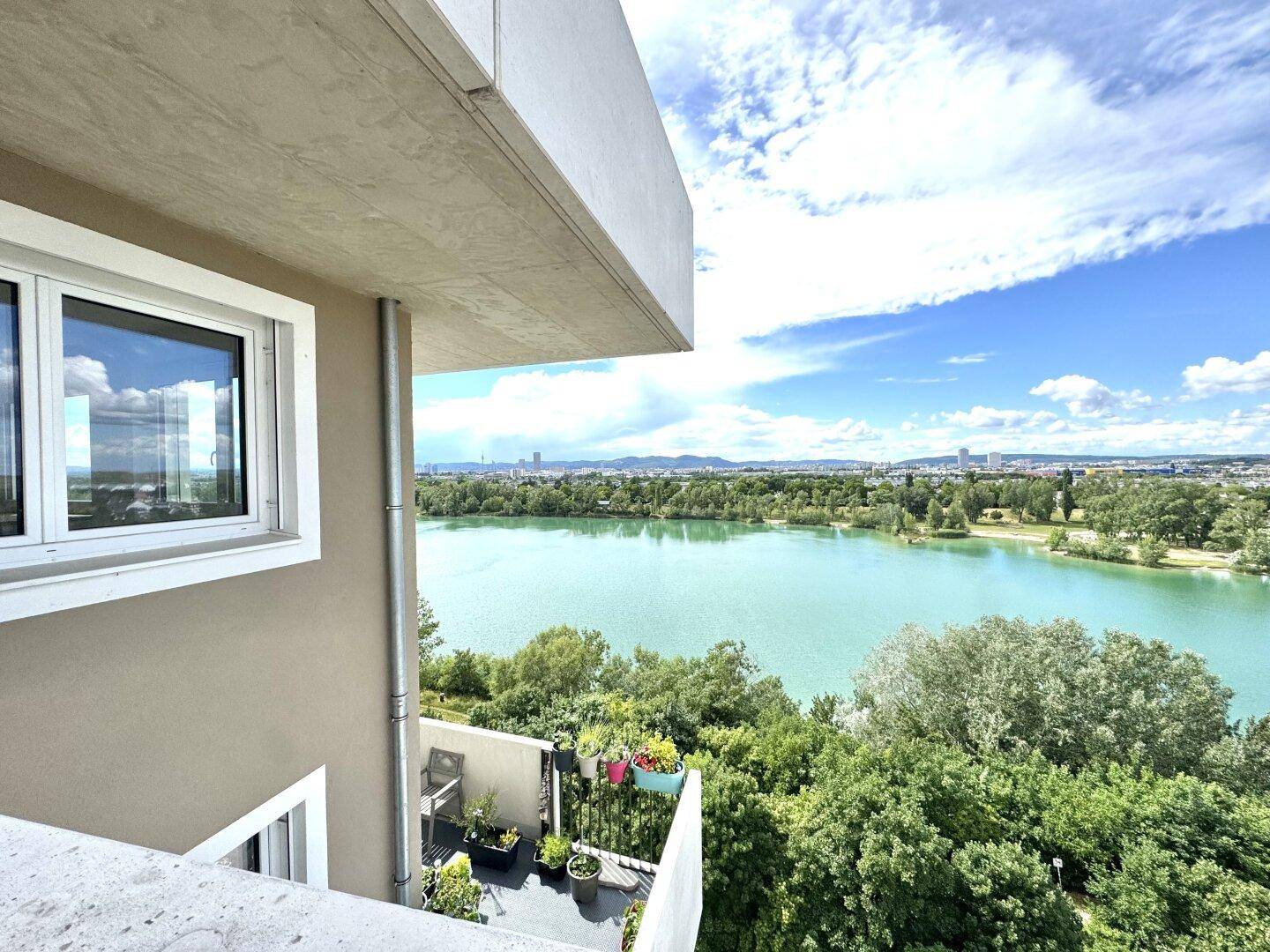 Heller Balkon mit Panoramablick über den See und die umliegende Landschaft.