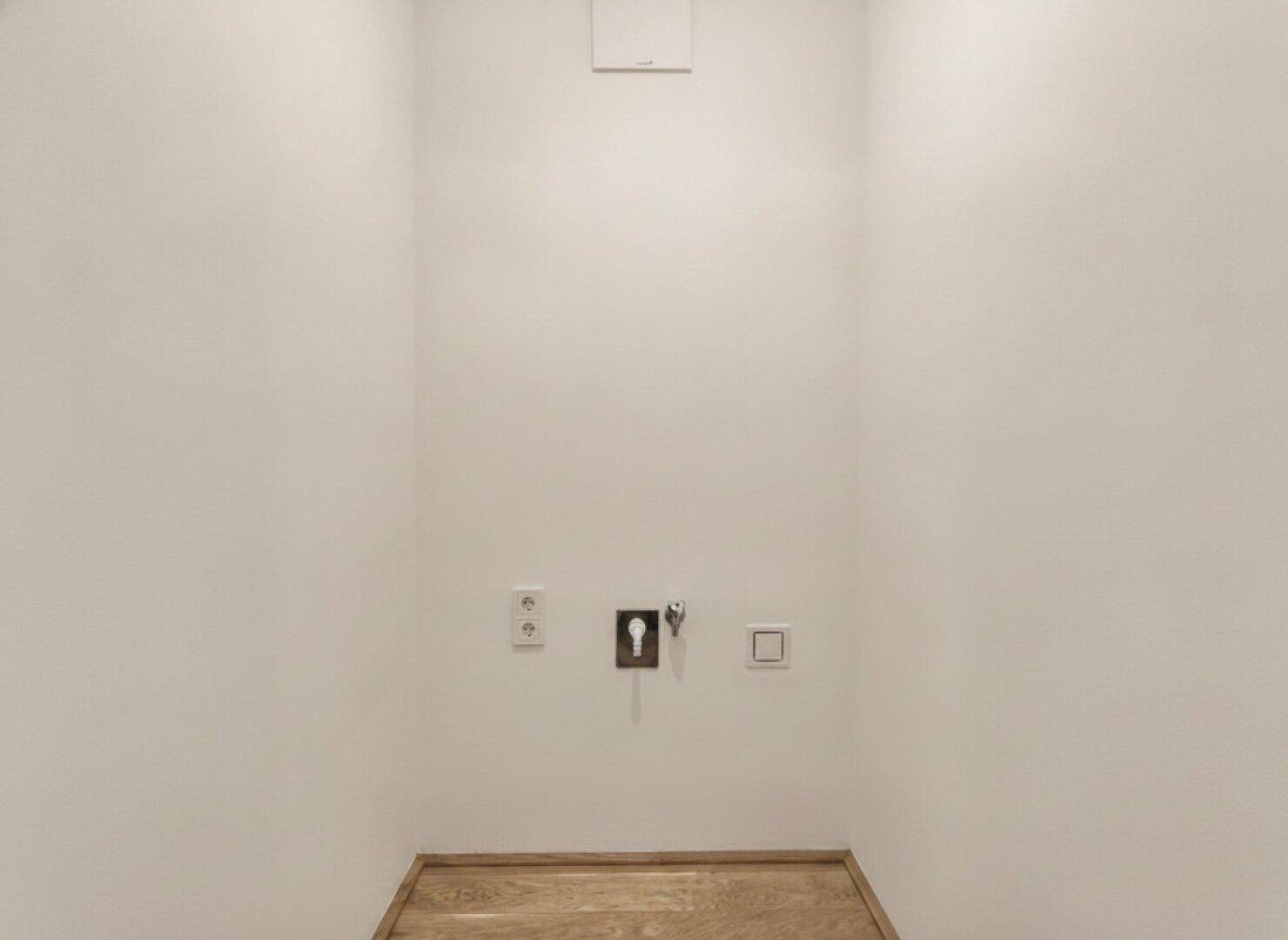 Kleiner Hauswirtschaftsraum mit Anschlüssen für Waschmaschine und Trockner, ideal für zusätzlichen Stauraum.