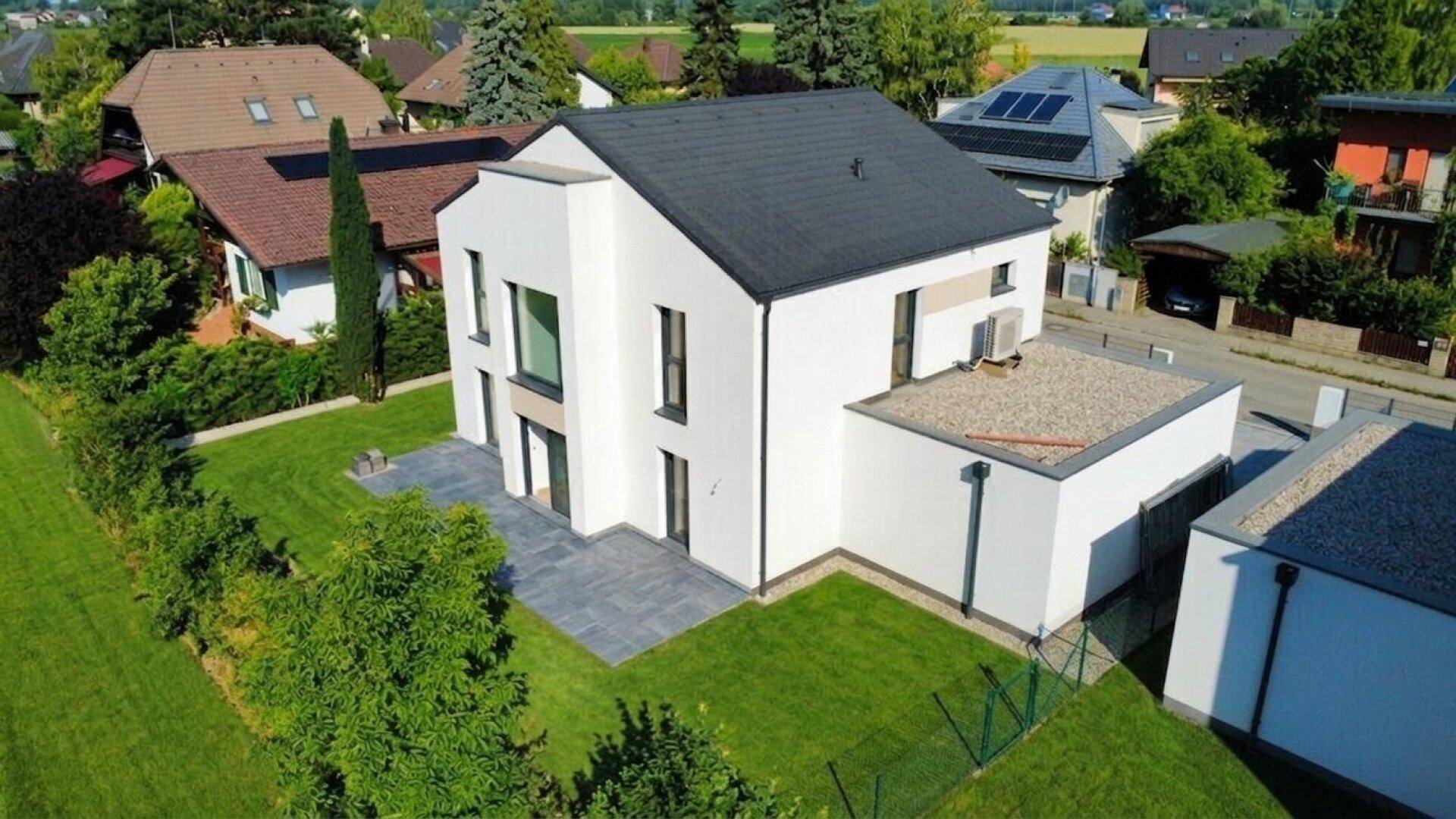 Moderne Architektur eines Einfamilienhauses mit gepflegtem Garten und Terrasse.