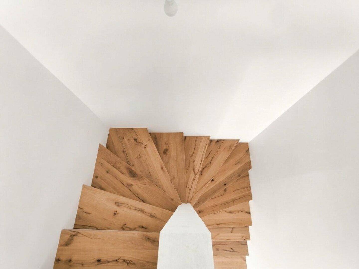 Elegante Holztreppe mit breiten Stufen, die die verschiedenen Ebenen des Hauses verbindet.
