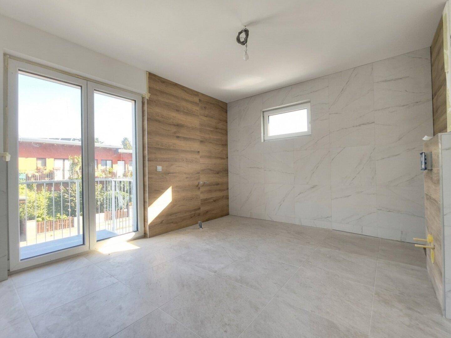 Badezimmer im Bau mit modernen Fliesen in Marmoroptik und Holzakzenten an der Wand.