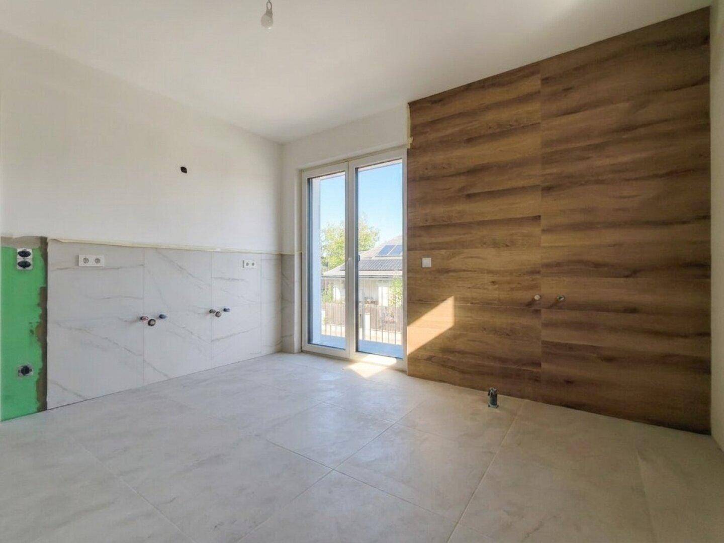 Badezimmer im Bau mit modernen Fliesen in Marmoroptik, Holzakzenten und vorbereiteten Anschlüssen.