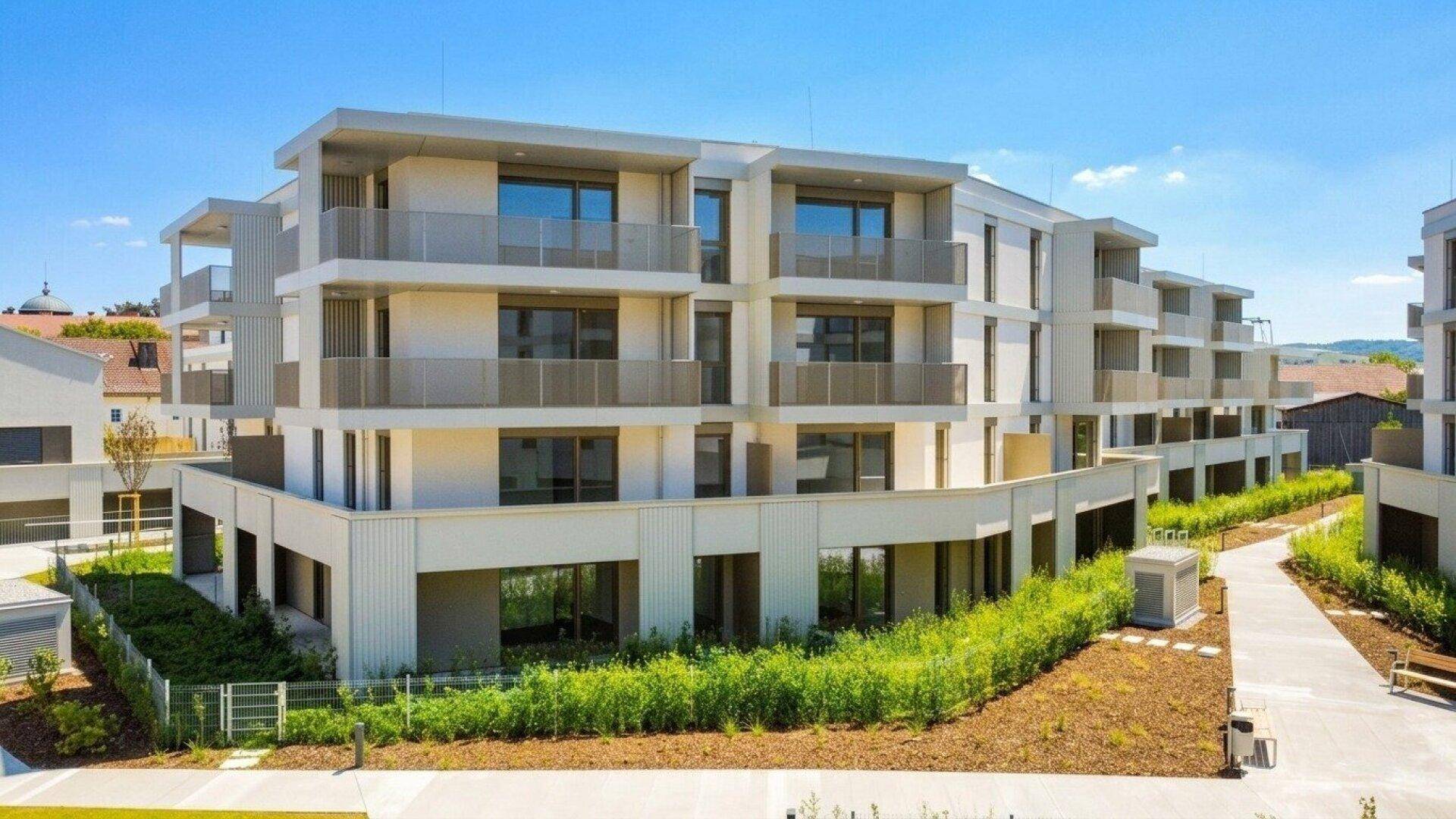 Ansicht eines modernen Apartmentgebäudes mit geschwungener Fassade und mehreren Balkonen.